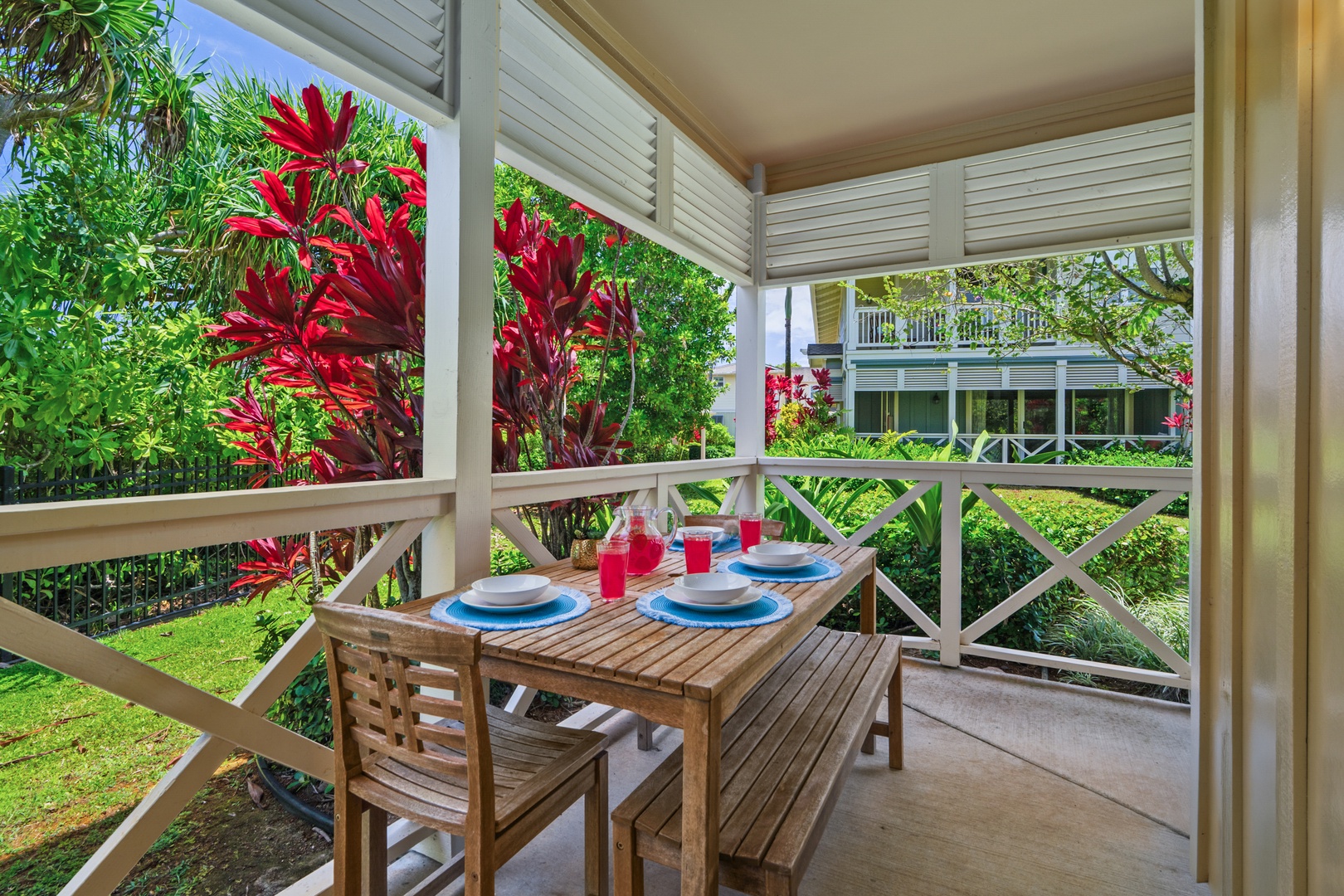Princeville Vacation Rentals, Kaimana Villa - Enjoy tropical dining on your covered lanai, surrounded by vibrant red foliage and lush gardens.