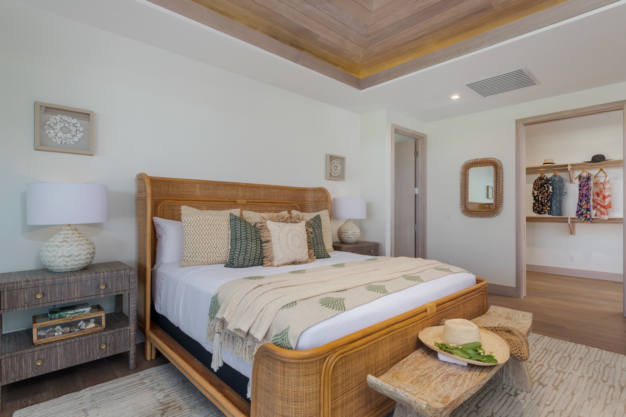 Waimea Vacation Rentals, 5BD Mauna Lani Lux Golf Estate (4) at One Ocean - This inviting bedroom features a richly crafted rattan bed frame that adds a touch of natural elegance to the space, complemented by soft, layered bedding that invites relaxation.