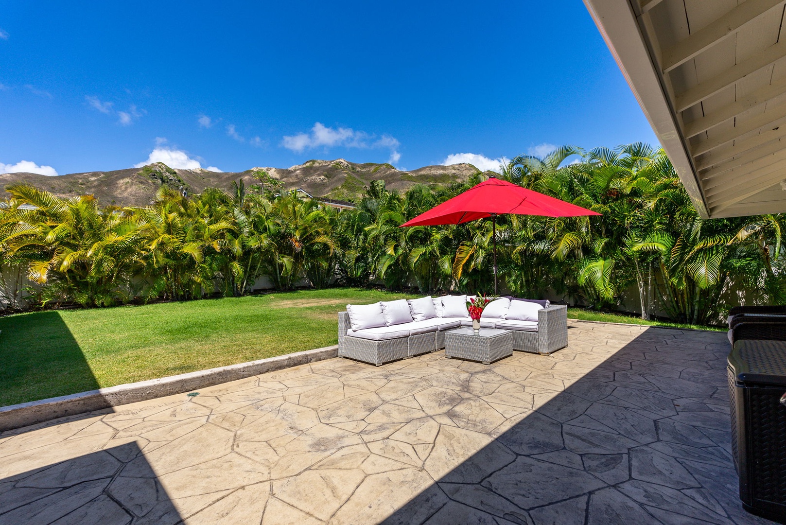 Kailua Vacation Rentals, Hale Alapi'i Lanikai Getaway - This inviting outdoor lanai offers a luxurious lounging area under a vibrant red umbrella