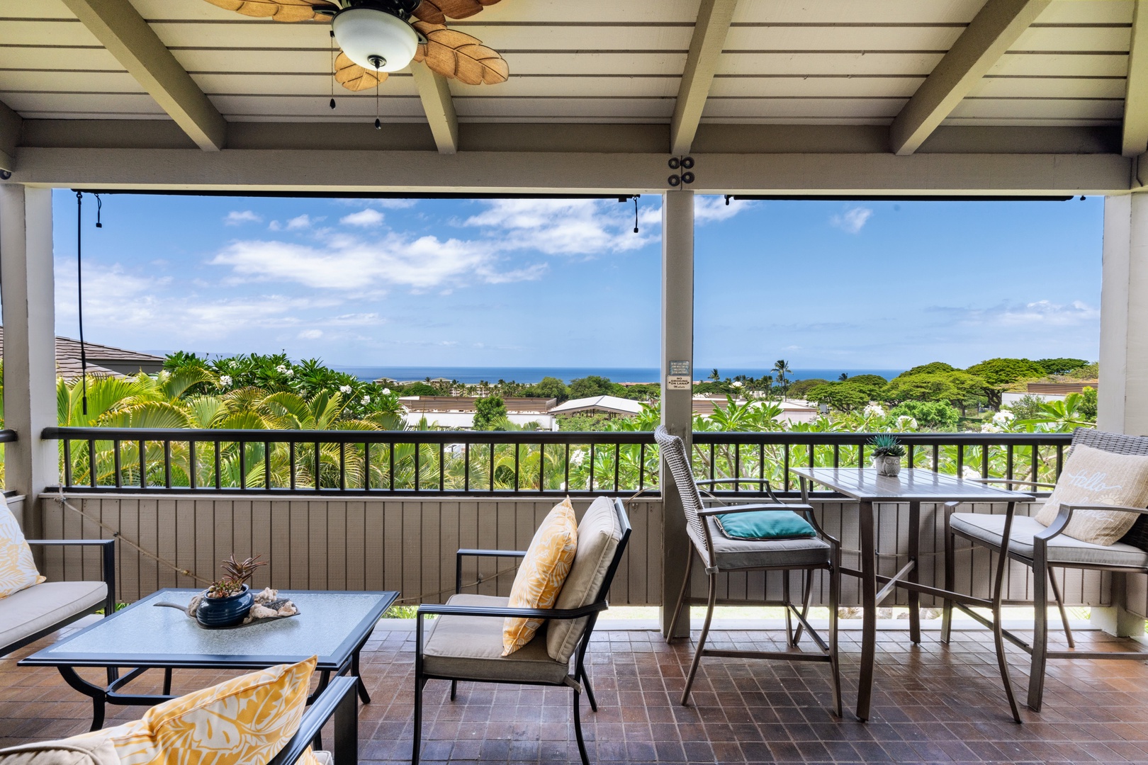 Kihei Vacation Rentals, Wailea Ekolu 204 - This end of the lanai opens onto a clean line of blue past the treeline, room enough for both the lounge chairs and the high table.
