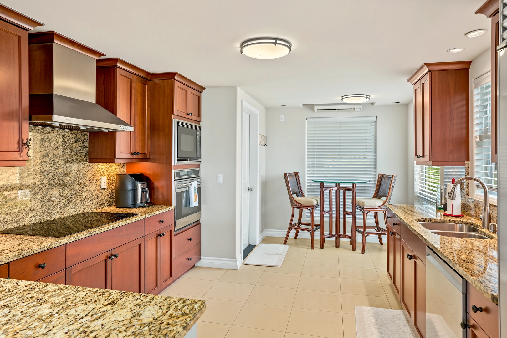 Princeville Vacation Rentals, Hale Hau'oli Moku - Cook the farmers market haul at the cooktop, under a stainless hood and mosaic tile.