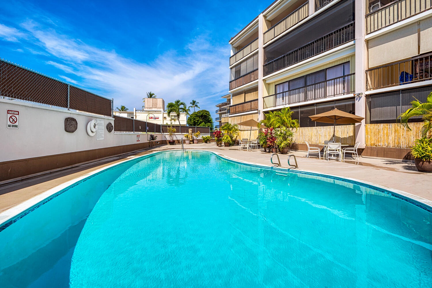 Kailua Kona Vacation Rentals, Kona Plaza 201 - Take a refreshing dip, surrounded by tropical palms and comfortable lounge chairs under the perfect blue sky.