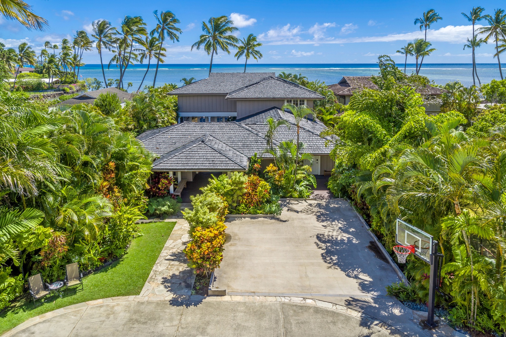 Honolulu Vacation Rentals, Moana Lani - Main House - A tropical drive up to the house, with the ocean just beyond the rooftops.