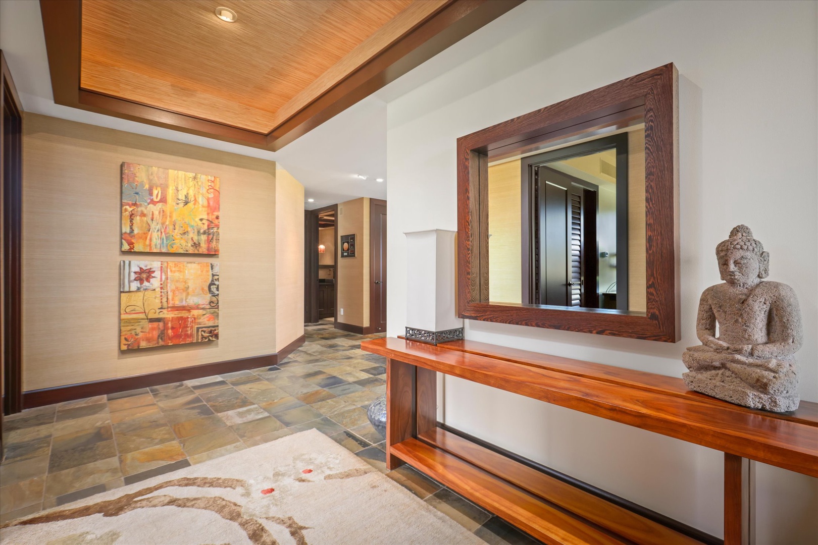 Kailua Kona Vacation Rentals, Wai'ulu Villa 115D - A curated entryway featuring warm textures, original art, and a mirror reflecting Hualalai elegance.