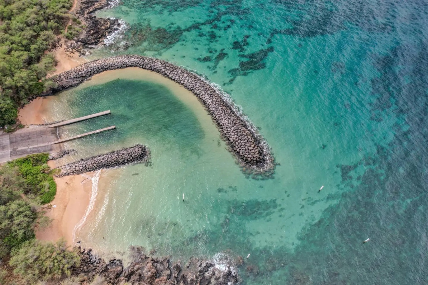 Kihei Vacation Rentals, Maui Kamaole E103 - Snorkelers work the reef just off the rocky jetty, visible right from the air.