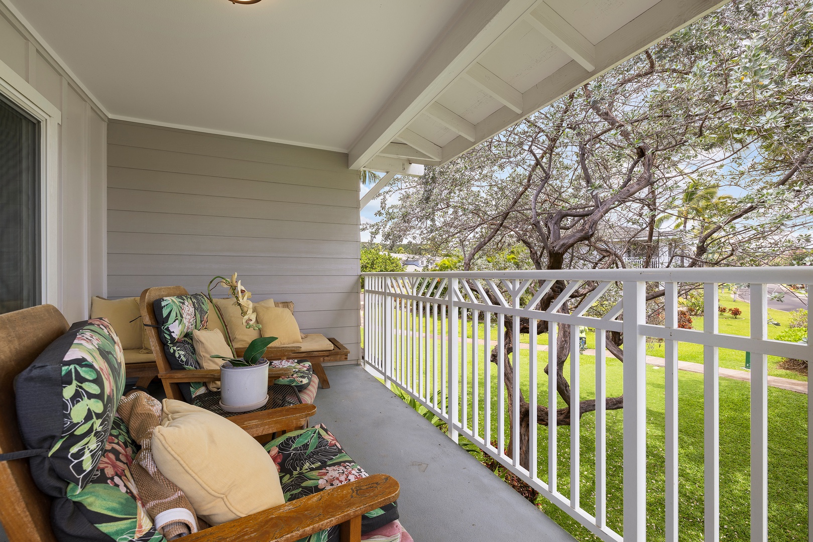Kapolei Vacation Rentals, Ko Olina Kai 1105E - Relax on your private balcony with comfy seating and garden views framed by a beautiful blossoming tree—your perfect spot for morning coffee or evening unwinding.