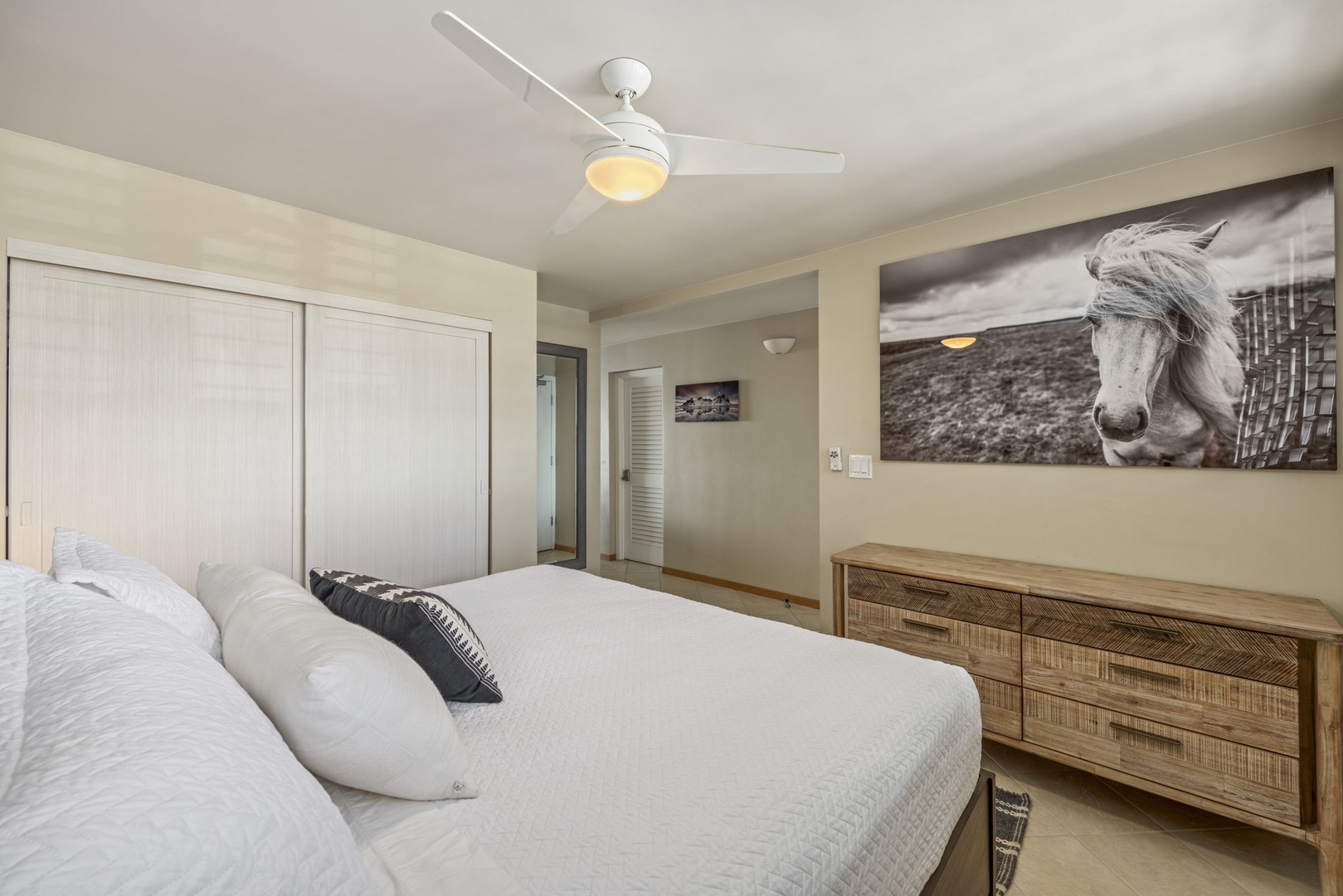Wailuku Vacation Rentals, Milowai 310 - A black-and-white horse photograph fills the wall in this bedroom, a low dresser doing the rest of the work.