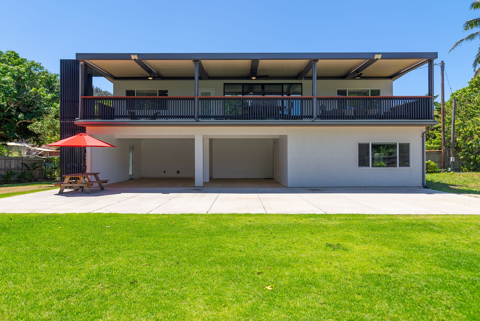 Haleiwa Vacation Rentals, Sunset Beach Island Retreat - This modern two-story home boasts a spacious yard, perfect for outdoor activities or relaxation. The expansive upper deck offers a shaded space to enjoy the breeze.