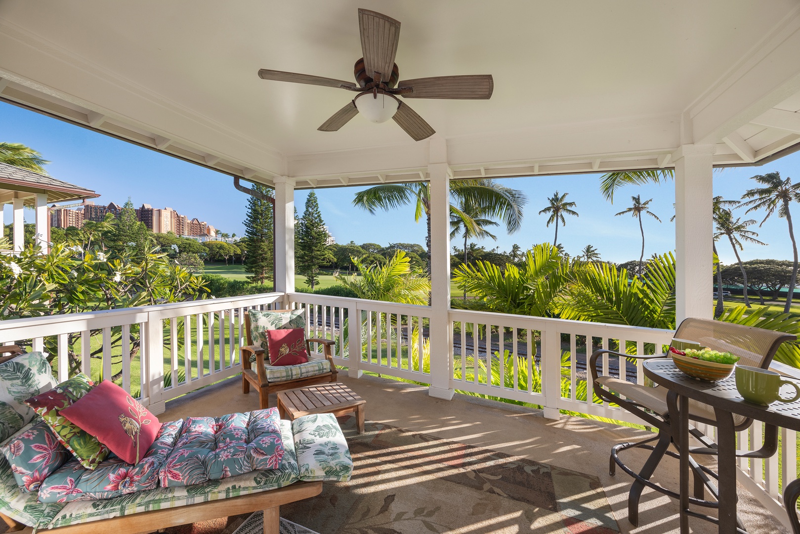 Your covered lanai offers tropical comfort with ceiling fan breezes and panoramic views of swaying palms and lush greenery.