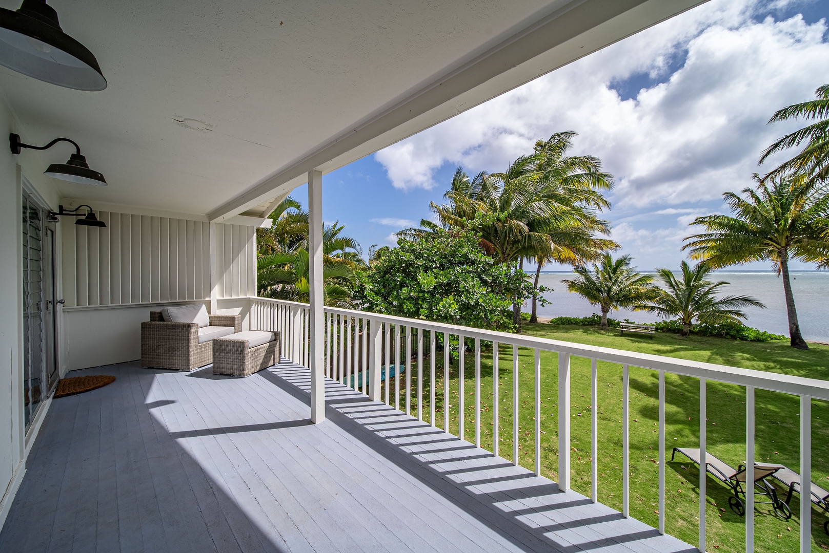 Honolulu Vacation Rentals, Honolulu Beachfront Retreat - Private balcony with wicker seating and sweeping ocean views, inviting guests to unwind with morning coffee or evening sunsets.