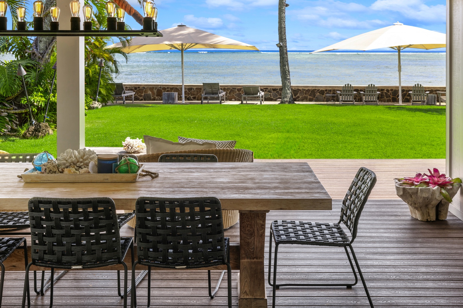 Honolulu Vacation Rentals, Moana Lani - Main House - Fresh flowers on the outdoor table, and the ocean framed between two shade umbrellas.