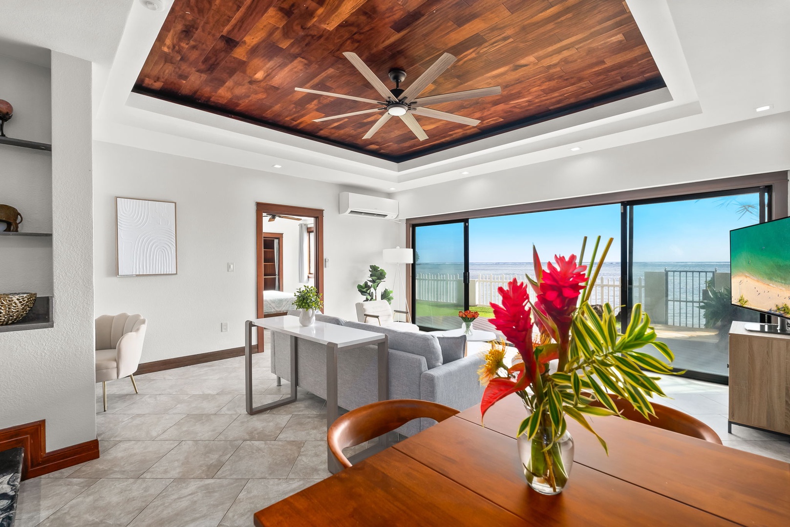 Honolulu Vacation Rentals, Wailupe Seaside 6 Bedroom - Dining area with seating for 4, featuring a vibrant floral centerpiece and warm wood accents.