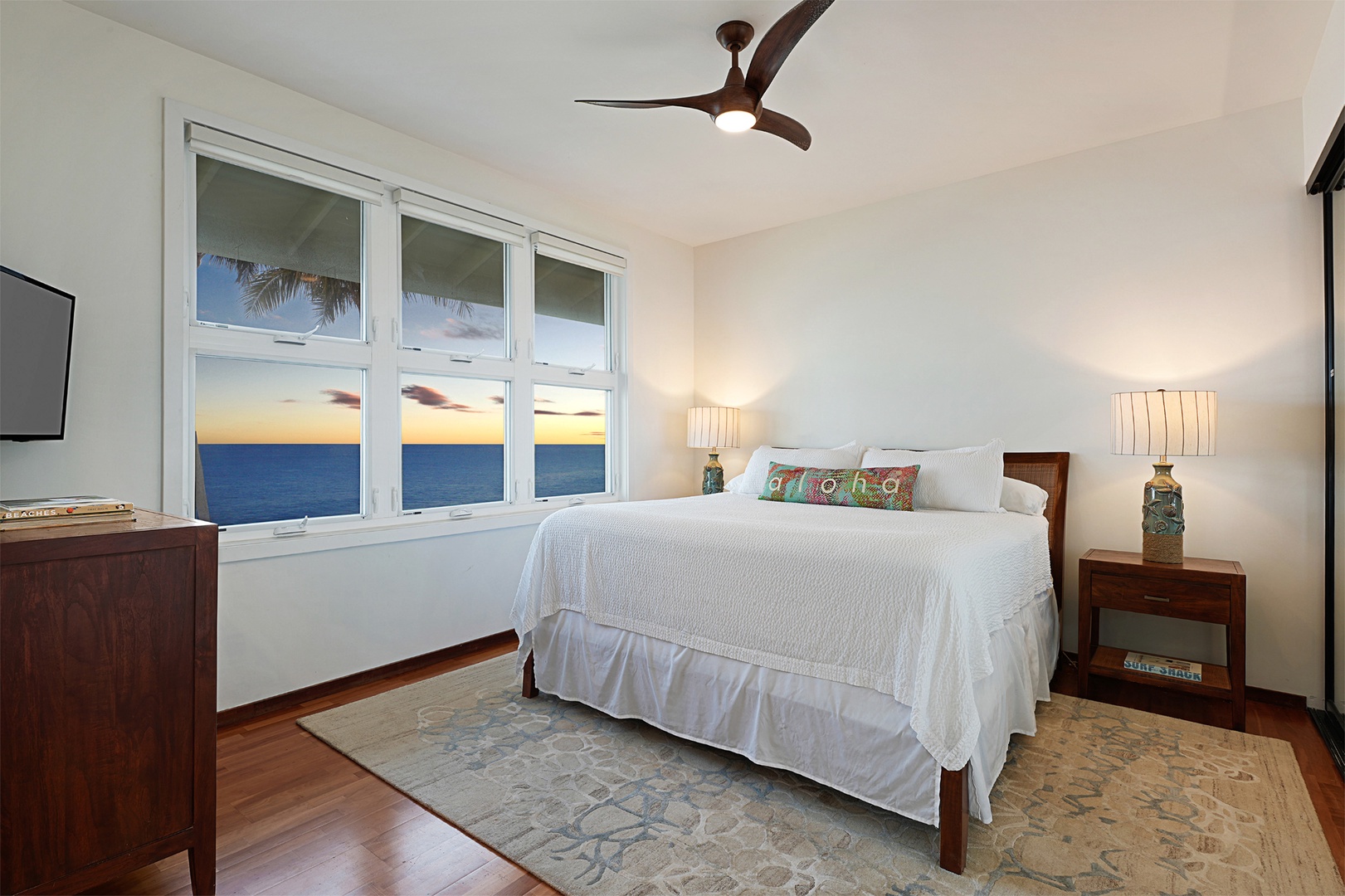 Koloa Vacation Rentals, Whalers Cove #133 - Guest bedroom with a king bed, large windows, and a serene oceanfront setting.