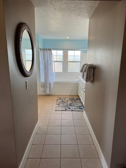 Princeville Vacation Rentals, Pili Aloha - Spacious ensuite bathroom with a soaking tub, shower, and dual sinks.