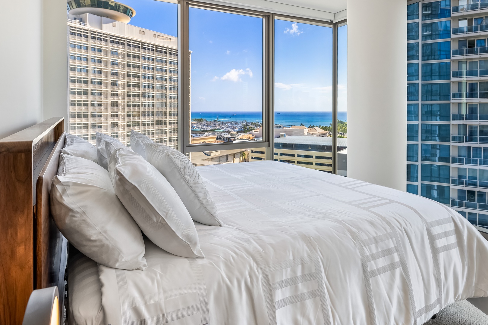 Honolulu Vacation Rentals, Sky Ala Moana #1701 - The suite has a comfortable bed and large windows, offering beautiful city and ocean views for a relaxing stay.