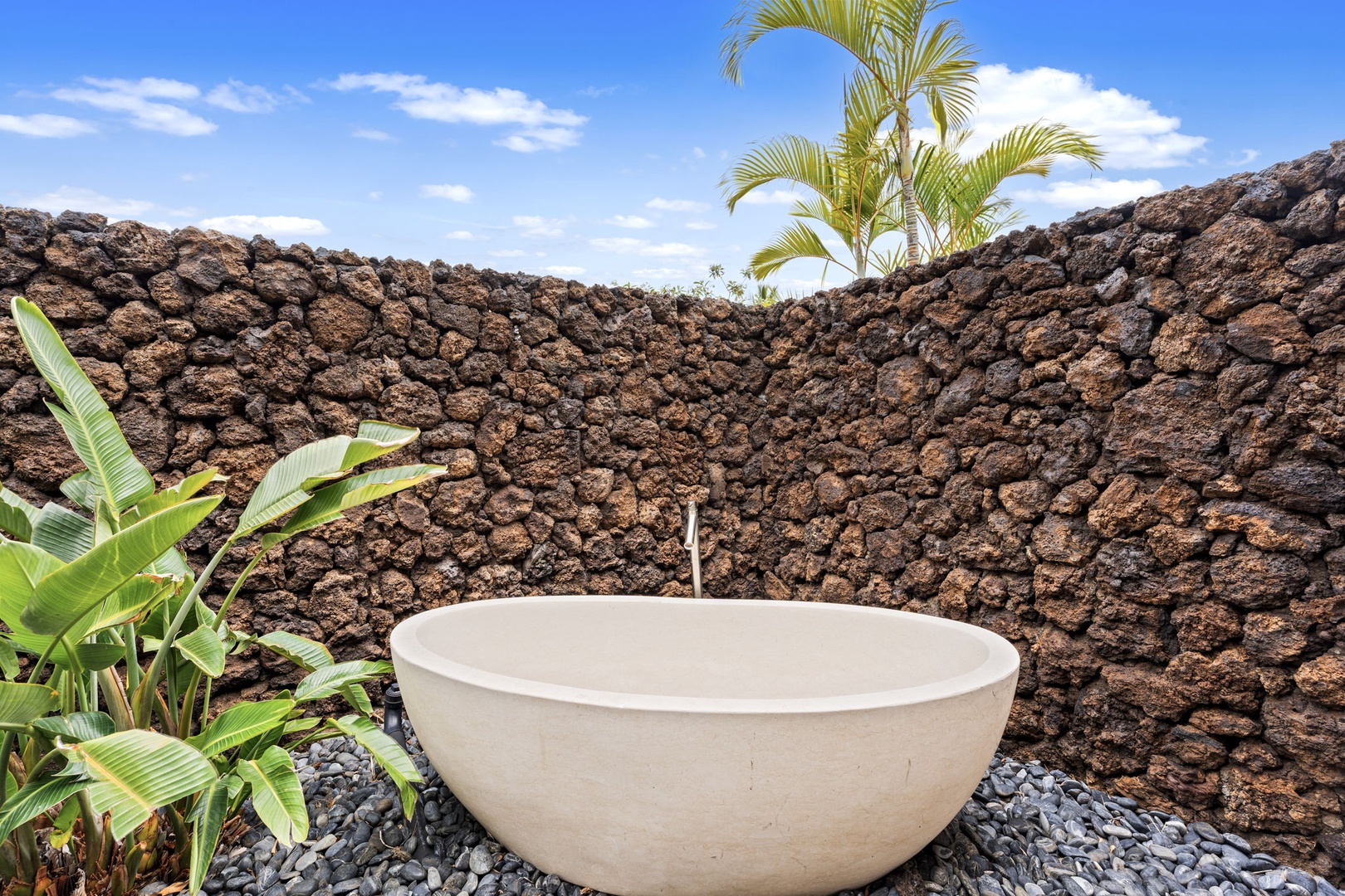 Kamuela Vacation Rentals, Hale Konane - Indulge in a serene open-air soak in this private outdoor bathtub retreat surrounded by lava rock walls.