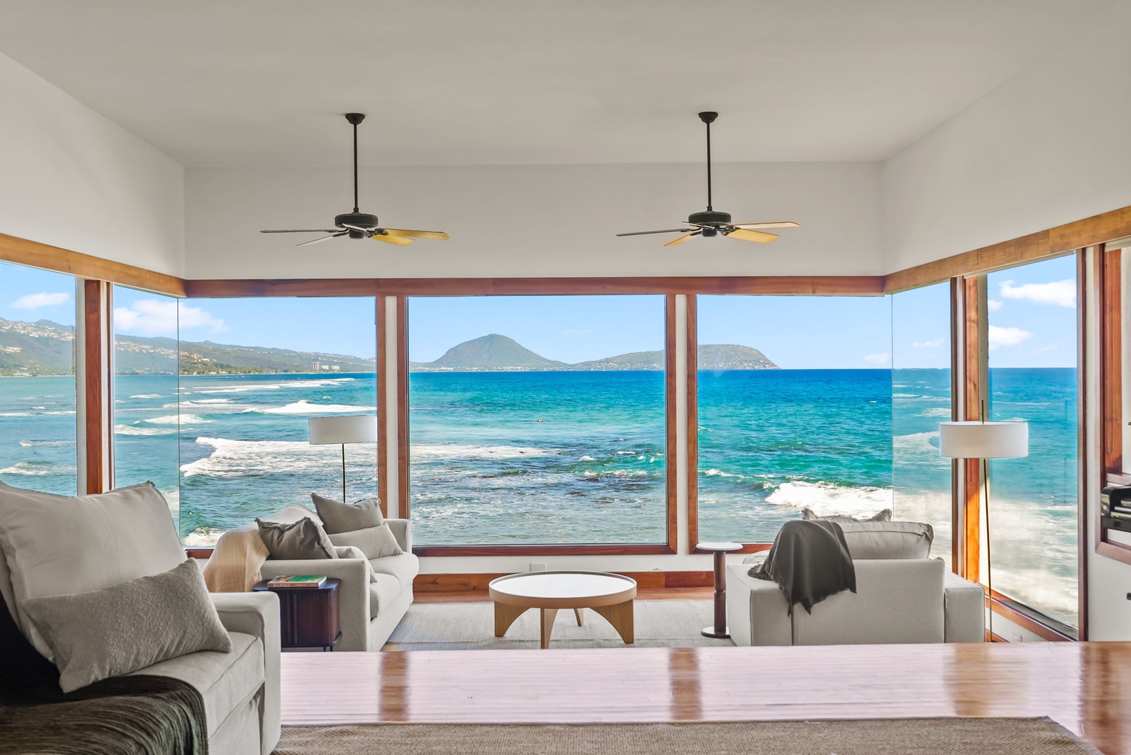 Honolulu Vacation Rentals, Black Point Ocean Villa - Sink into plush seating and watch waves crash against pristine shores through floor-to-ceiling windows offering breathtaking ocean panoramas.
