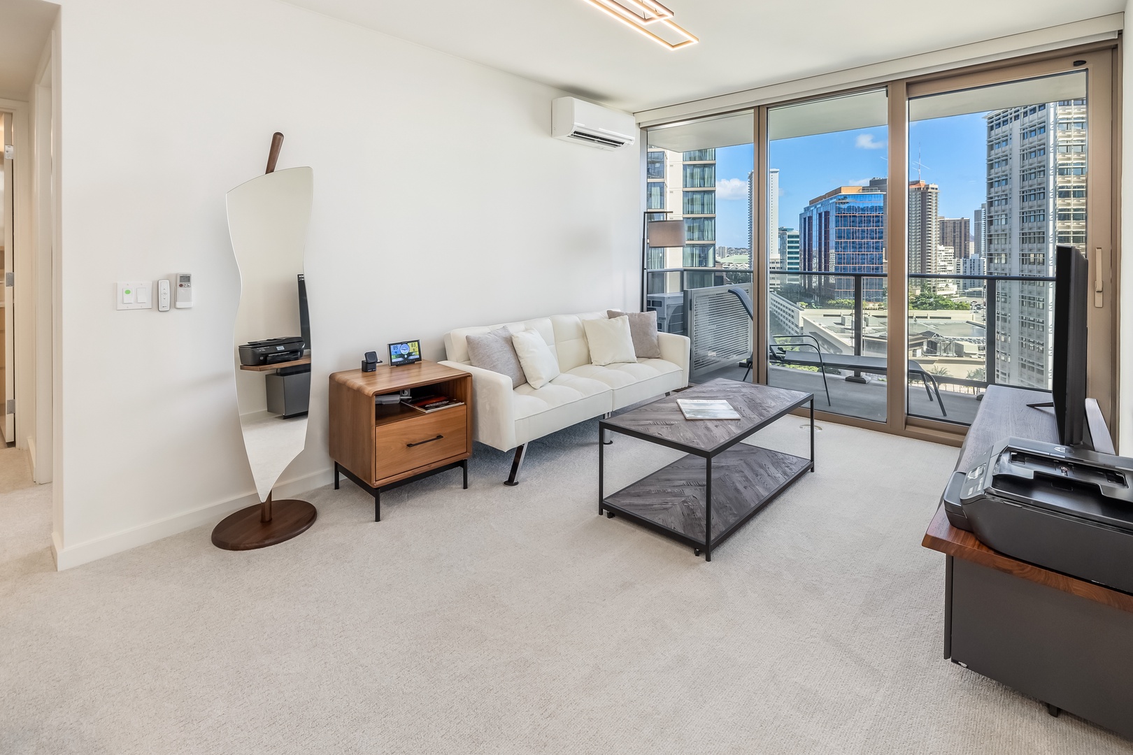 Honolulu Vacation Rentals, Sky Ala Moana #1701 - Cozy living area with a comfy sofa and floor-to-ceiling windows, offering city views and natural light.