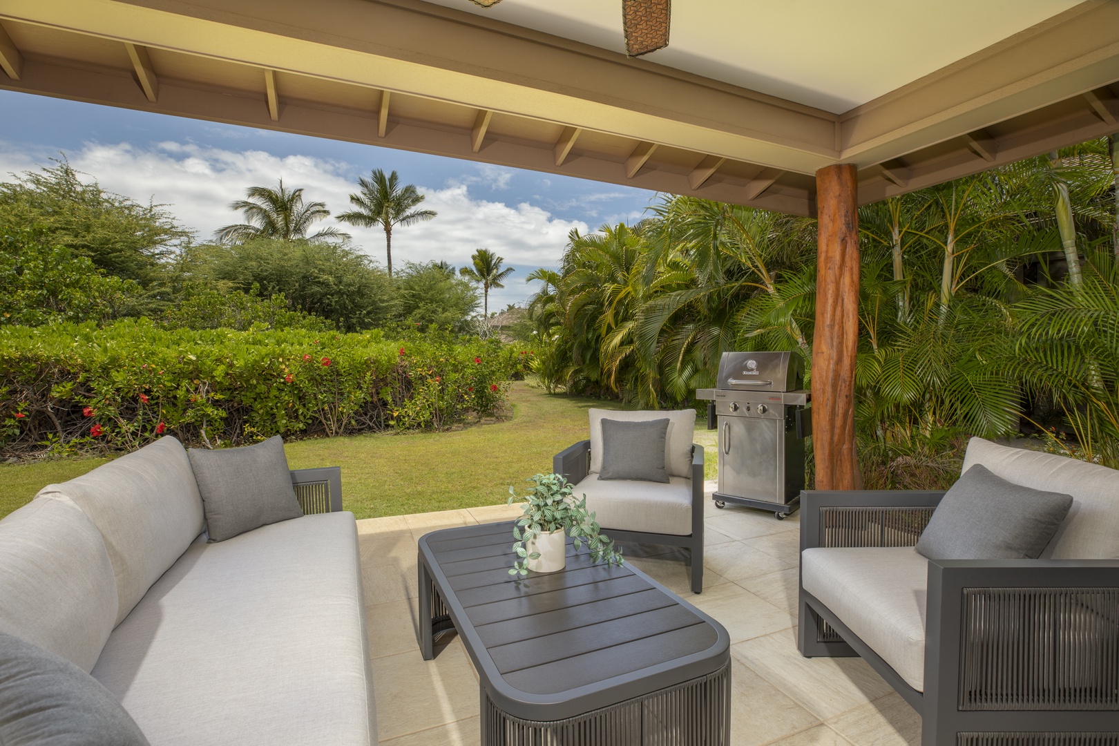 Kamuela Vacation Rentals, Mauna Lani KaMilo #503 - Sip coffee or grill dinner in your serene lanai lounge, framed by lush greenery and swaying palms.