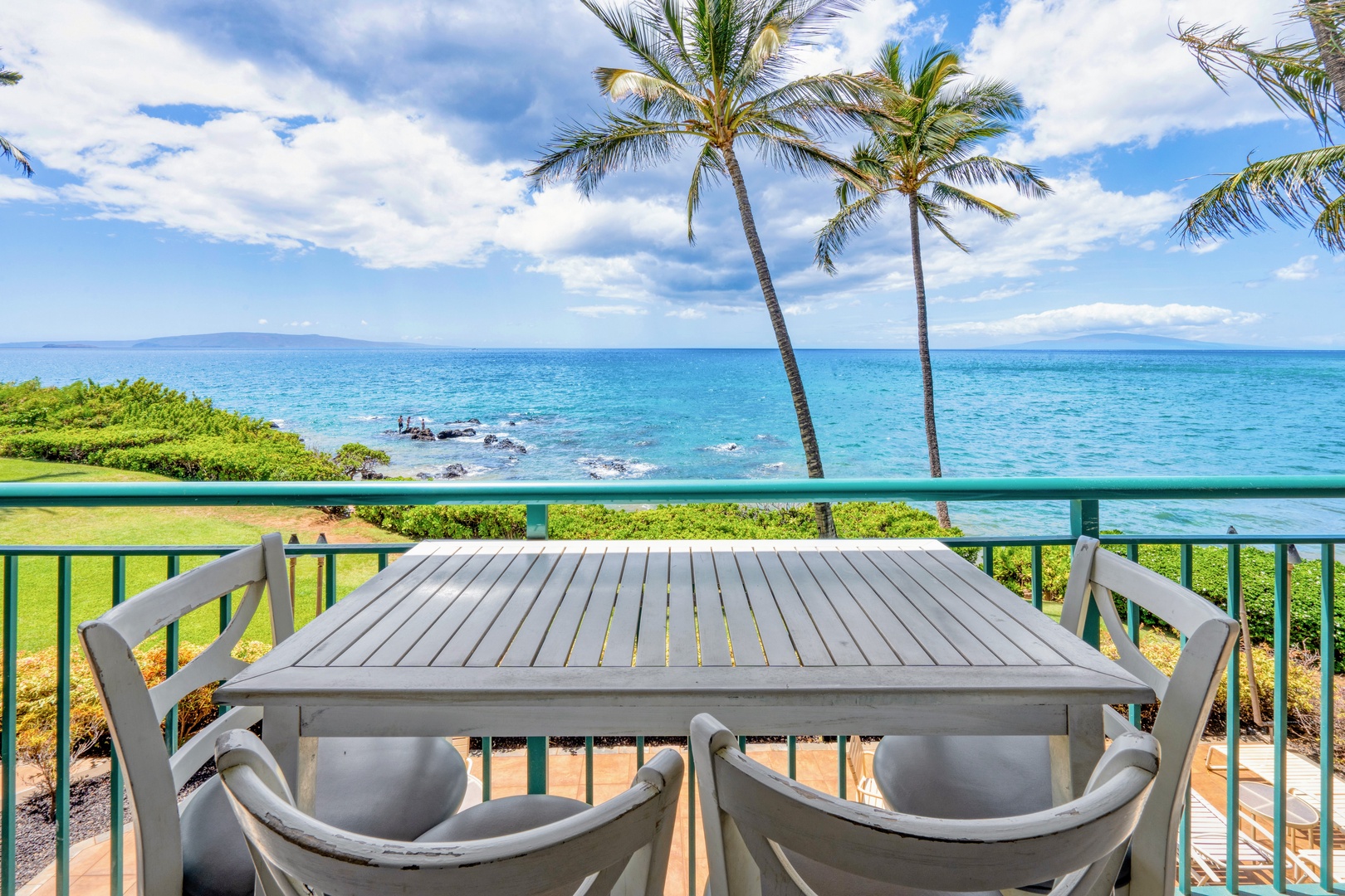 Kihei Vacation Rentals, Punahoa Beach 205 - Palms lean over the lanai table, framing a clean line of blue to the horizon.