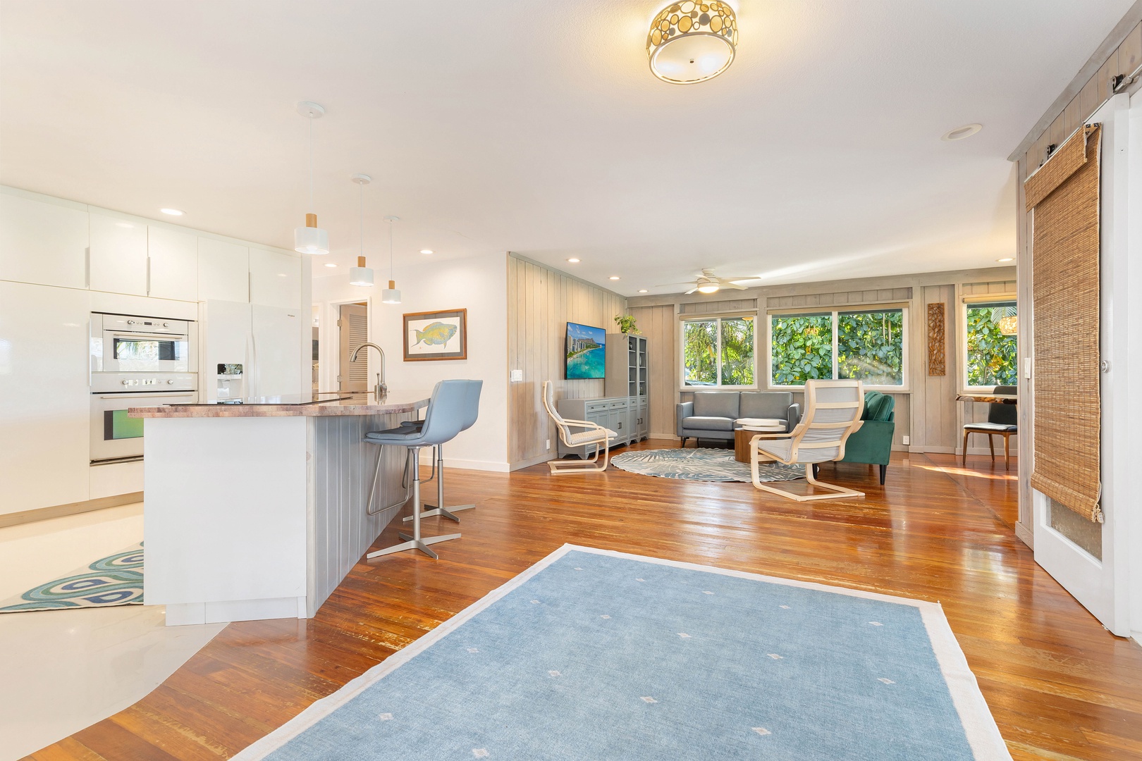 Haleiwa Vacation Rentals, Velzey Ohana Villa (4B Vacation Home) - Bright and airy open-concept layout with wood flooring and a central dining space for group gatherings.