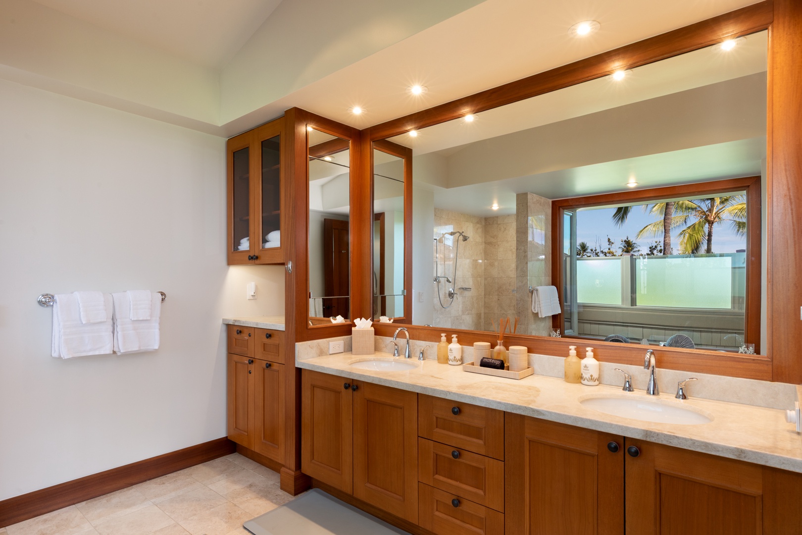 Kailua Kona Vacation Rentals, 3BD Waiulu Villa (111D) at Hualalai Resort - Your spacious primary bathroom features dual vanities, rich wood cabinetry, and a tropical palm view to start your mornings peacefully.