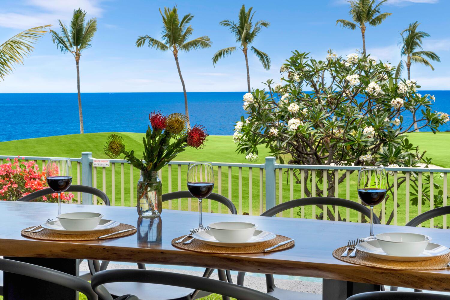 Kailua-Kona Vacation Rentals, Holua Kai #26 - Dine with a view: Enjoy meals at this outdoor table set against a stunning backdrop of the ocean and tropical flora.
