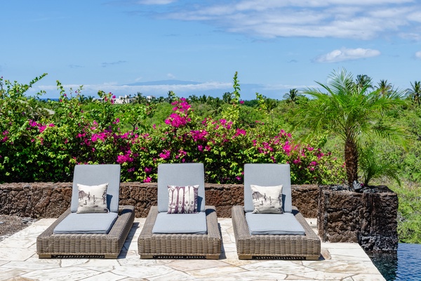 Kamuela Vacation Rentals, Canoe House & Beach Walker at Champion Ridge - Poolside lounge chairs with vibrant tropical plants in the background, offering a relaxing spot to soak up the sun.