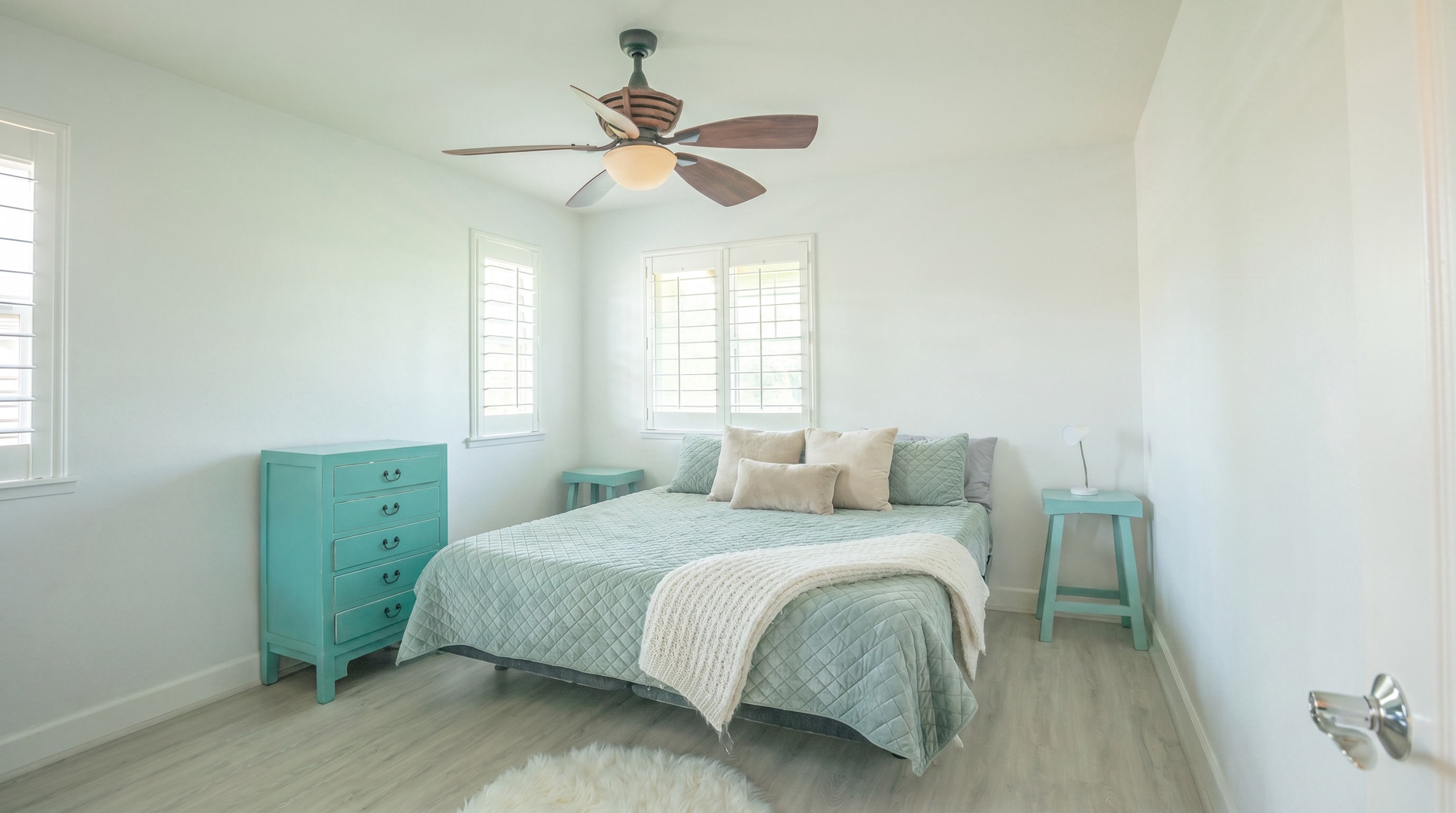 Sleep under a ceiling fan in a bright bedroom trimmed in teal.