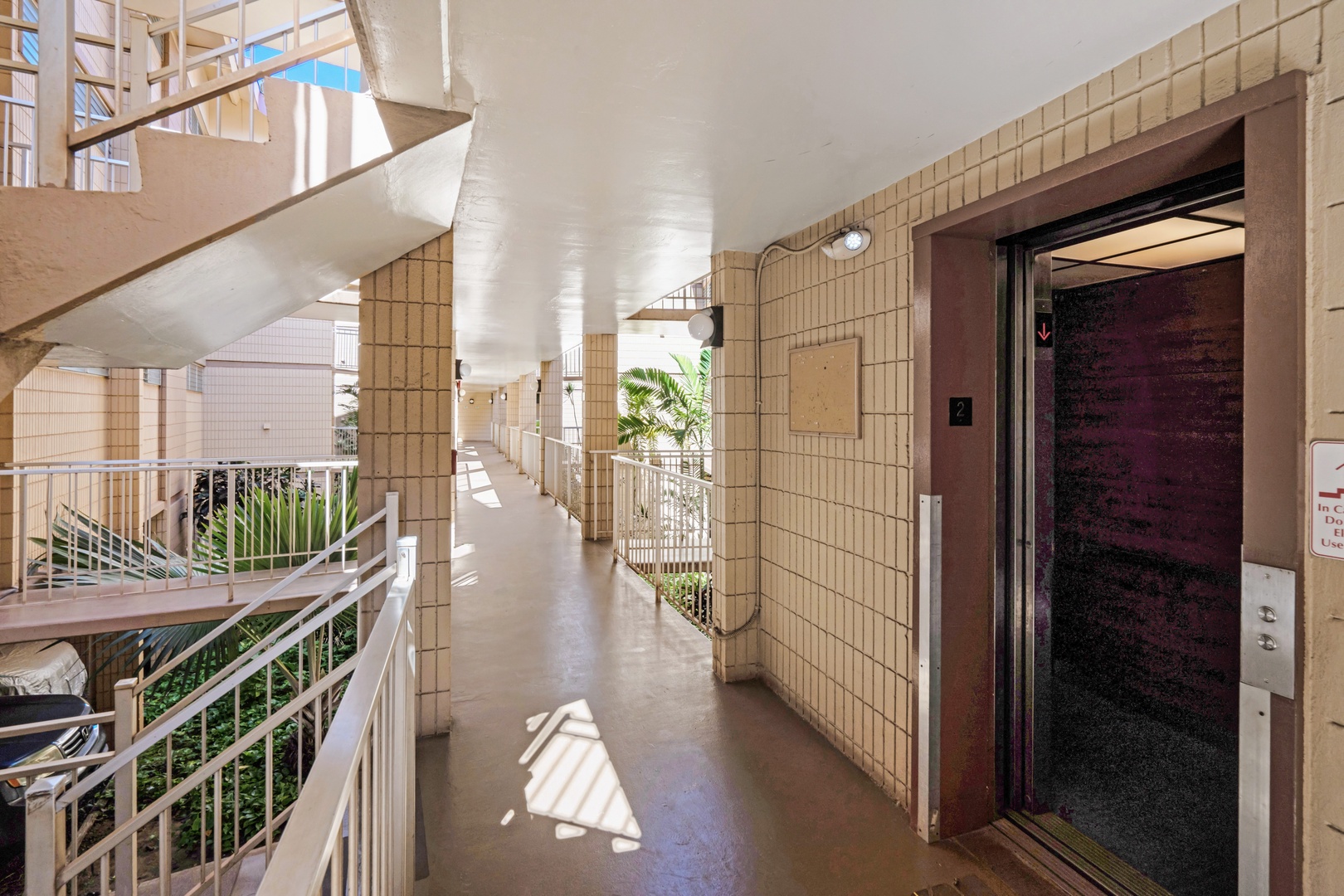 Kihei Vacation Rentals, Haleakala Shores A206 - An elevator marked 2 opens right onto this floor's open-air breezeway, tile walls warmed by the afternoon sun.