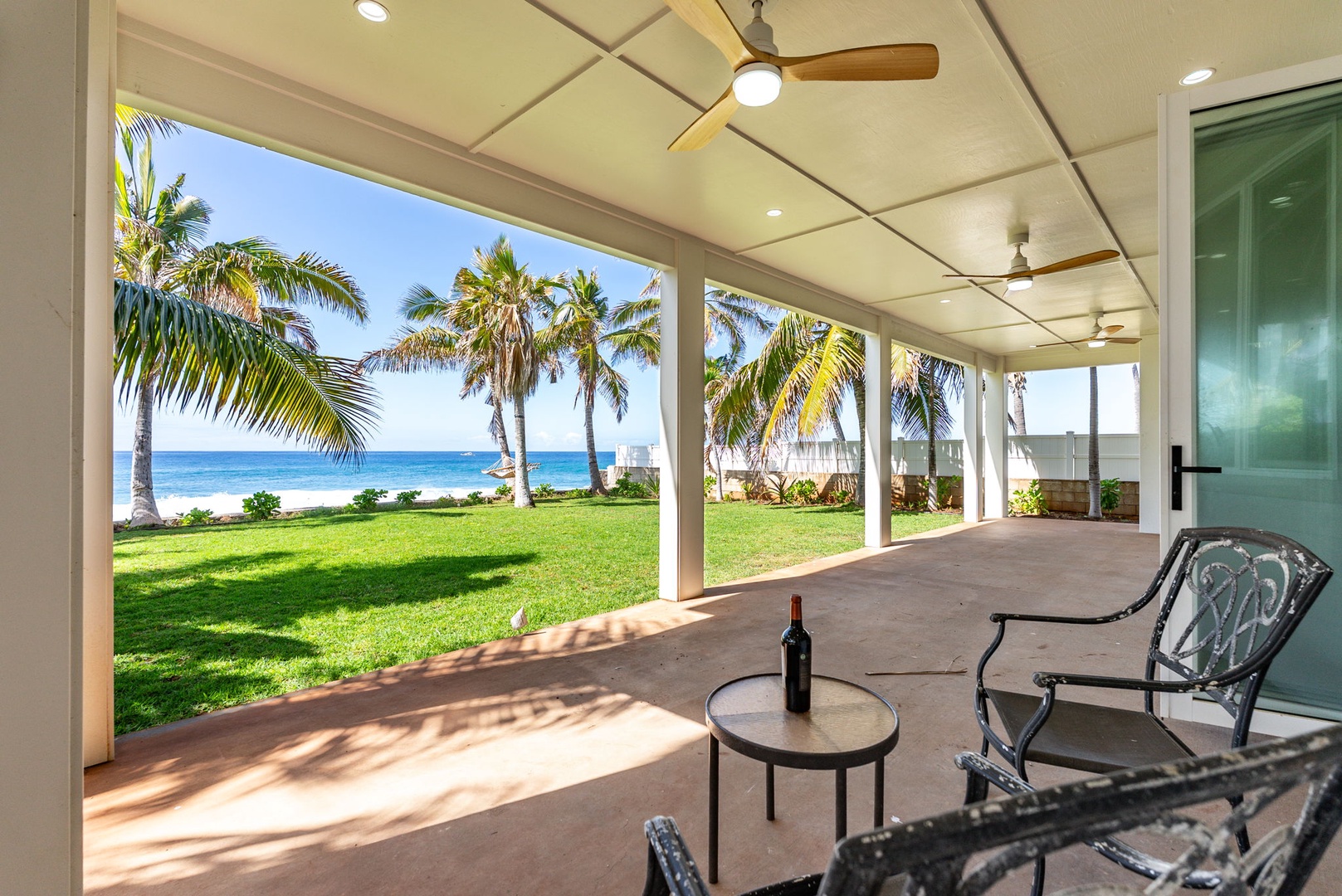 Waianae Vacation Rentals, Oceanfront Luxury Dream Estate - Covered dining lanai with palm-framed views for breezy sunset meals or tropical drinks.