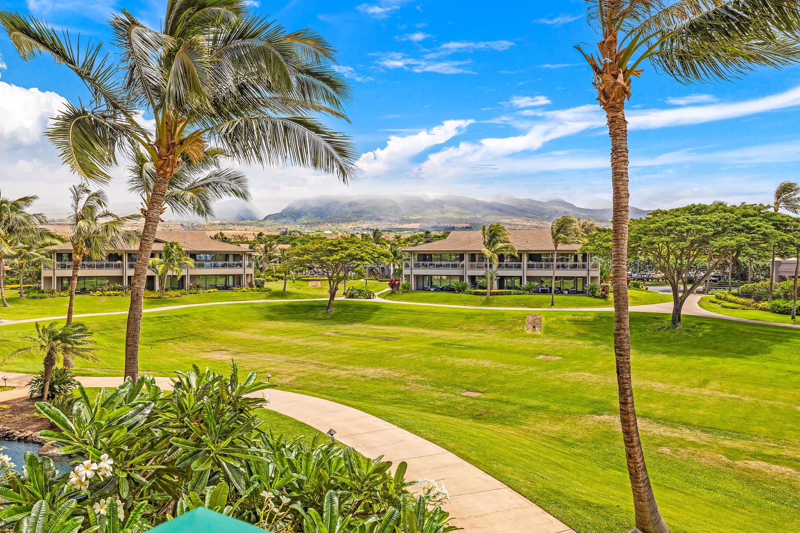 Lahaina Vacation Rentals, Honua Kai Konea 206 - Lush green lawns and swaying palm trees provide a tranquil view, with the stunning backdrop of the mountains in the distance.