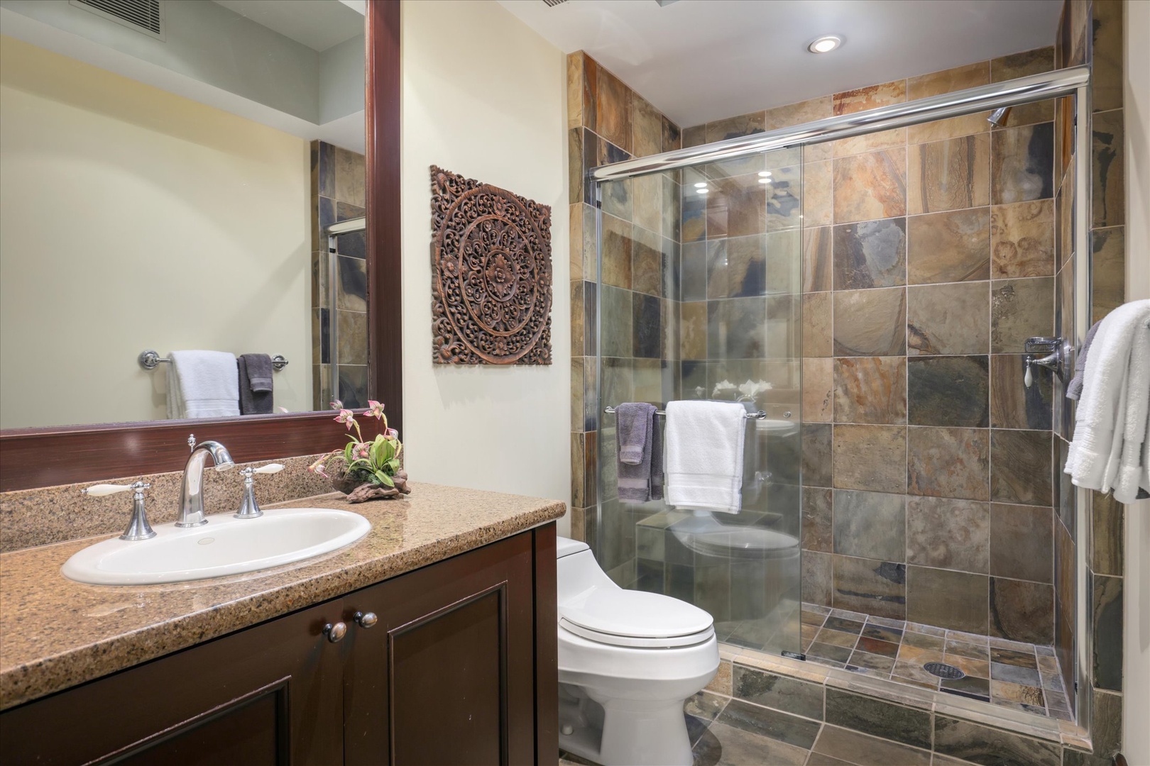Kailua Kona Vacation Rentals, Wai'ulu Villa 115D - Guest bathroom with stone tile walk-in shower and granite vanity—luxurious yet practical.