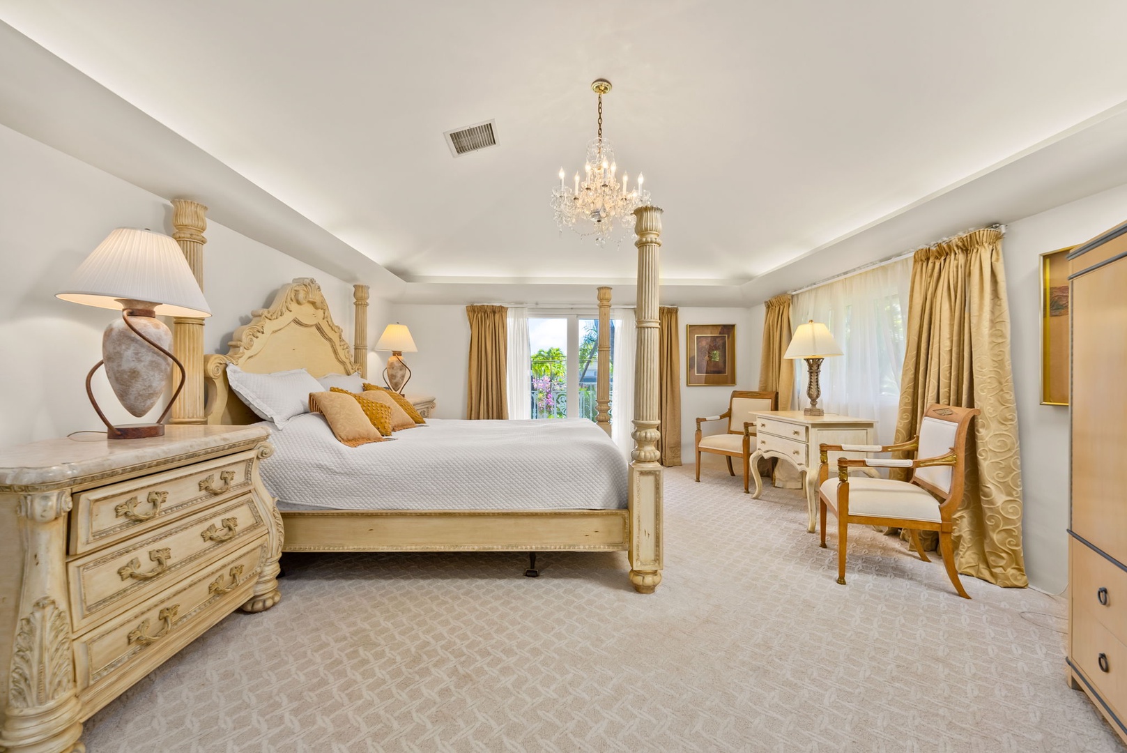 Honolulu Vacation Rentals, Kahala Oasis - Opulent primary suite featuring a four-poster bed, chandelier, and classic decor for a restful and elegant atmosphere.