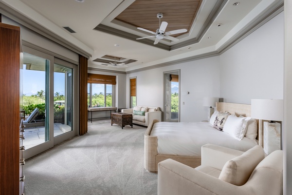 Kamuela Vacation Rentals, Canoe House & Beach Walker at Champion Ridge - Spacious primary bedroom with king-sized bed, elegant ceiling details, plush seating, and large windows offering natural light.