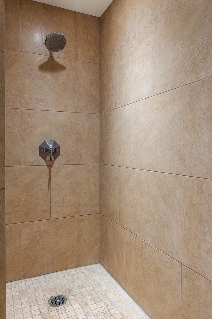 Step into your private walk-in shower featuring elegant beige tile, modern fixtures, and a spacious design that invites relaxation after a long day of exploring.