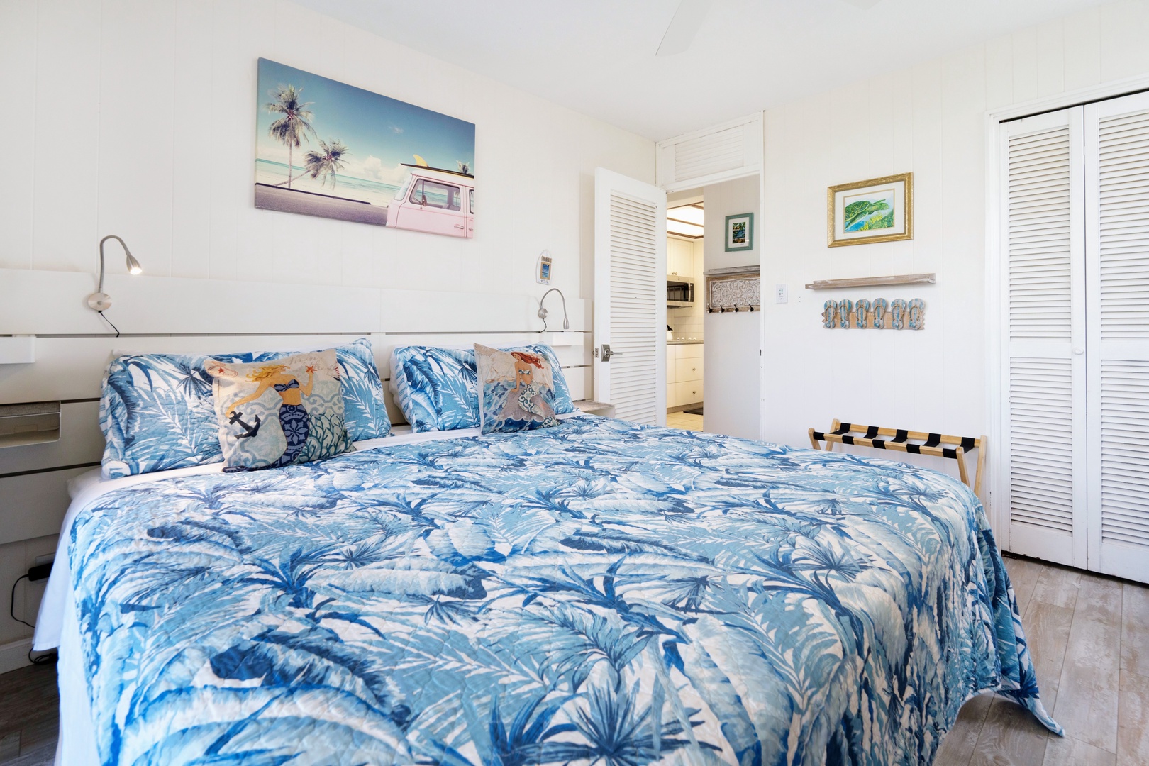 Kihei Vacation Rentals, Punahoa Beach 205 - The king bed sits beneath a fun piece of art, with the kitchen just through the open door.