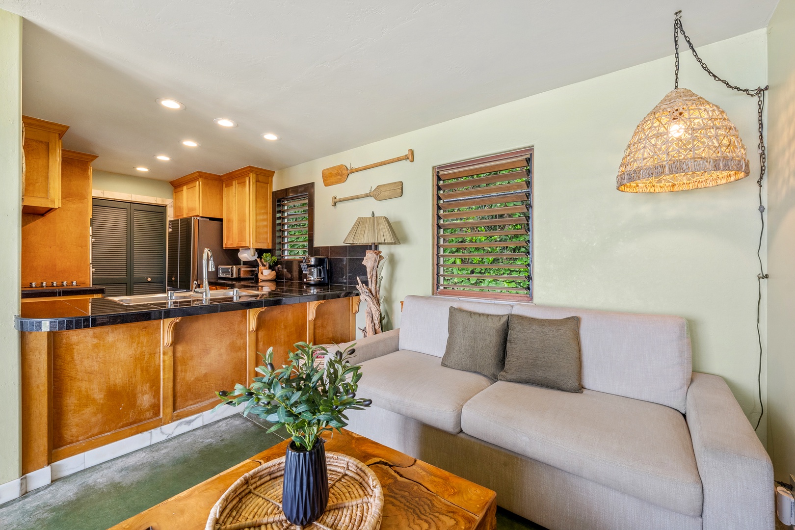 Hanalei Vacation Rentals, Hale Kepuhi - Unwind in your open-plan living space where warm wood cabinets and soft lighting create the perfect tropical retreat atmosphere.