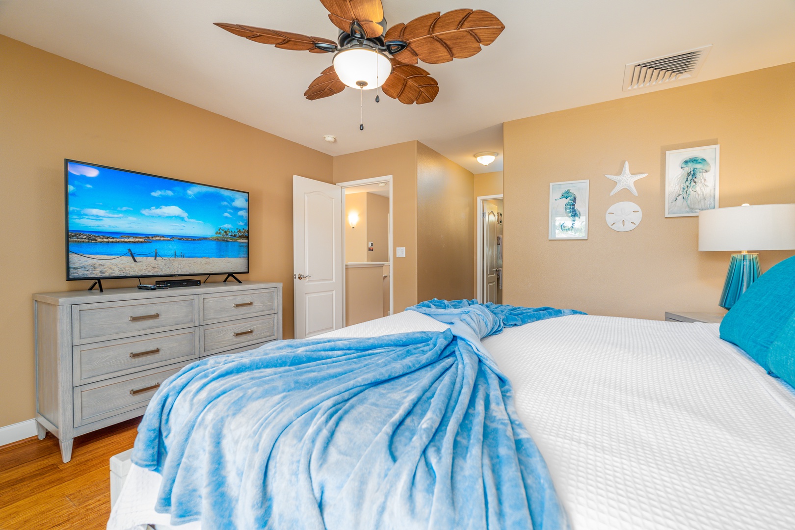 Kapolei Vacation Rentals, Ko Olina Kai 1081C - The primary guest bedroom upstairs with a dresser and TV.