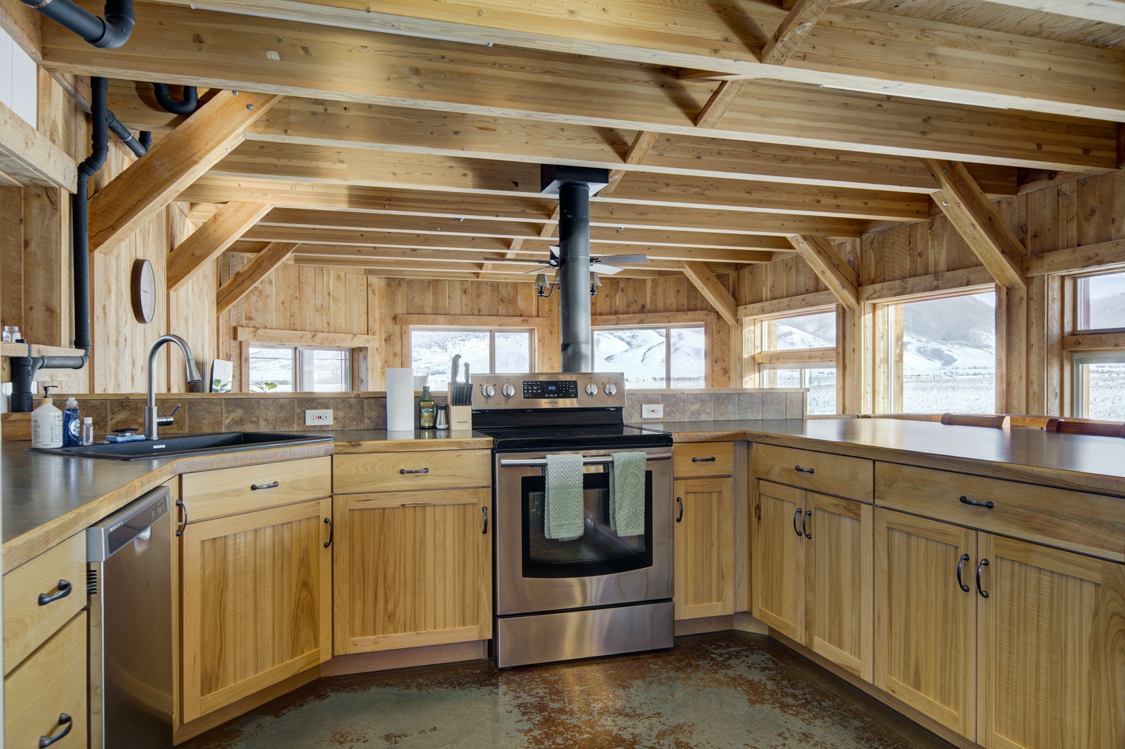 Livingston Vacation Rentals, OFB Sunset Grove - Custom-made cabinetry and sleek countertops, it contains all your cooking essentials, including a gas range, microwave, refrigerator, stovetop oven, and more. On top of that, you'll find state-of-the-art dishwater on the other side to make cleaning up eas