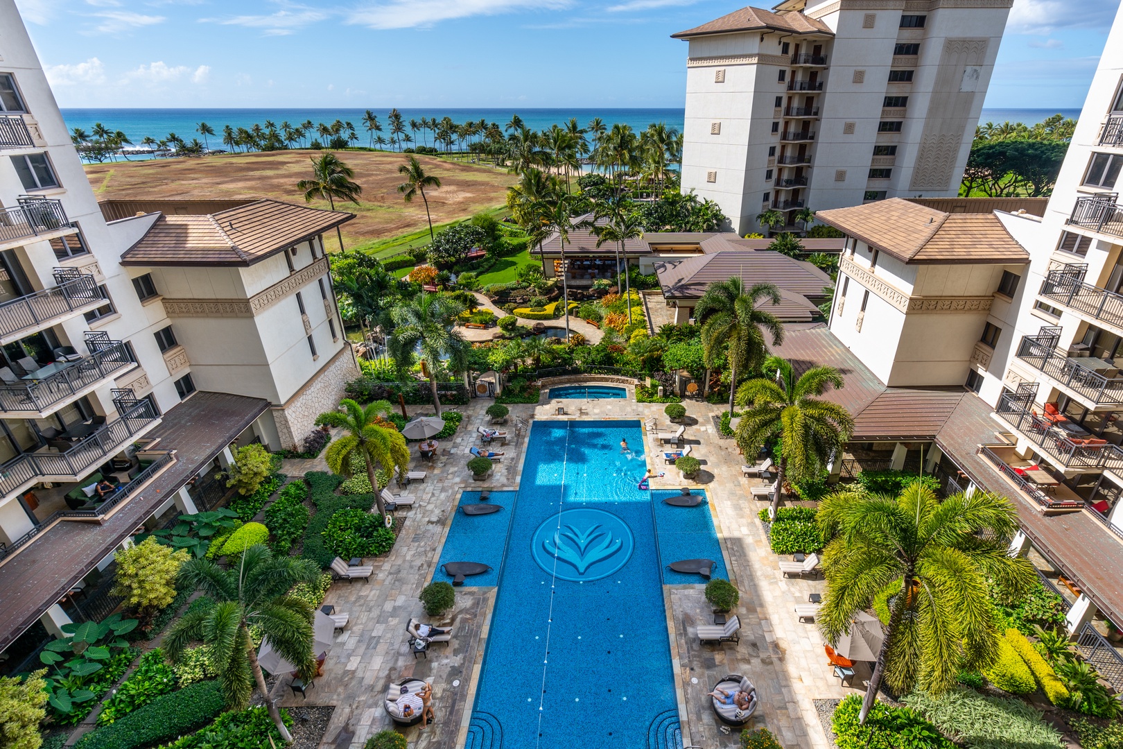 From above, the pool runs long and blue between the buildings out toward the water.