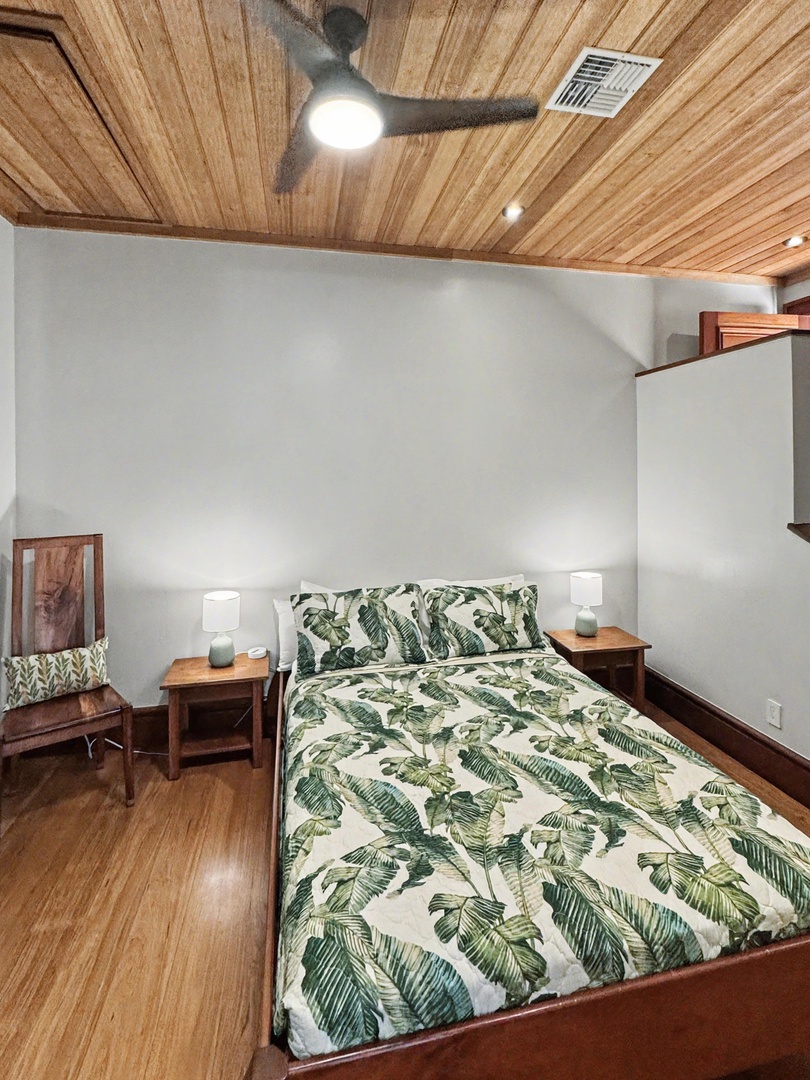 Kailua-Kona Vacation Rentals, Hahalua Bay Villa - Unwind in your cozy bedroom with tropical leaf bedding, warm wood ceilings, and gentle ceiling fan creating the perfect retreat.