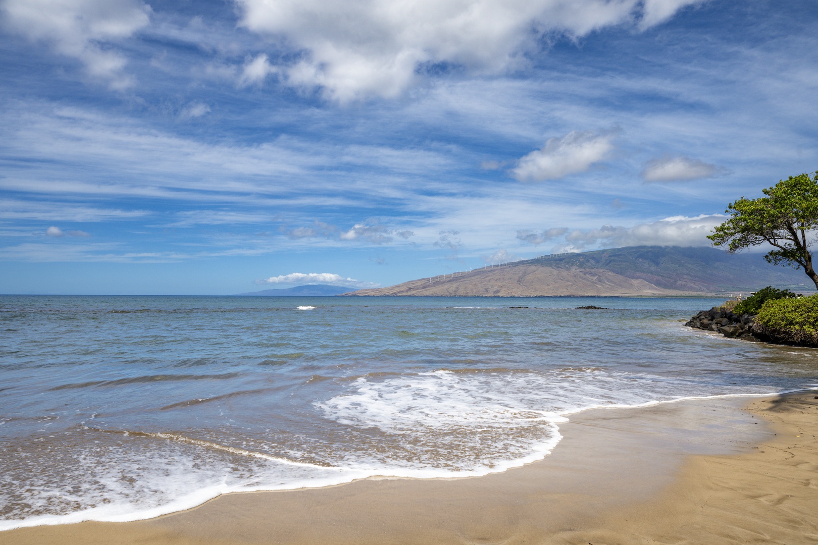 Kihei Vacation Rentals, Kihei Bay Surf B212 - Pristine beach with gentle waves lapping golden sand beneath dramatic mountain backdrop and expansive blue sky.