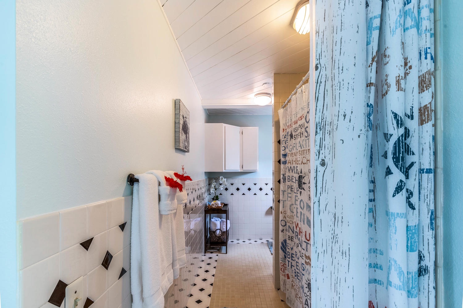 Princeville Vacation Rentals, Pineapple Suite - A whimsical bathroom hallway with unique patterned tiles and a cozy design.