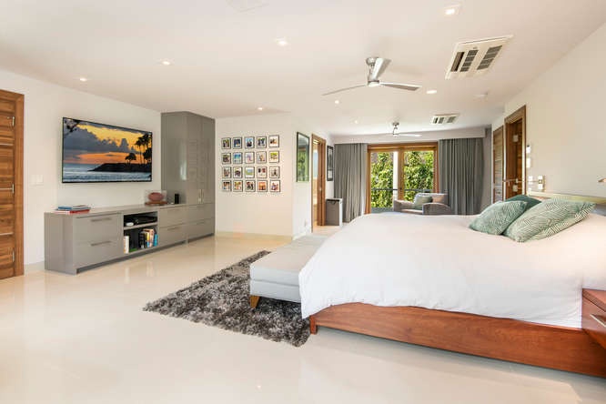 Honolulu Vacation Rentals, Diamond Head Beachfront Estate - Second-level guest bedroom with asian king bed, lounge space, and peaceful garden views.