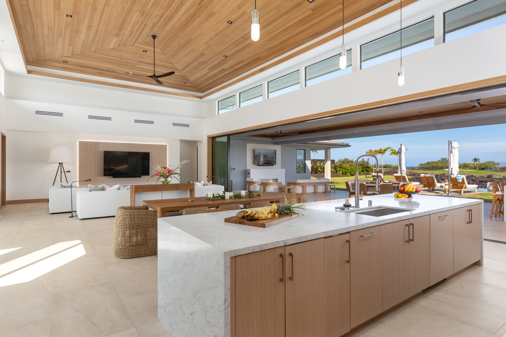 Kamuela Vacation Rentals, 5BD Mauna Lani Lux Ocean Estate (OE12) at One Ocean - Your spacious open-plan kitchen flows into the living area, where warm wood and marble create an elegant cooking space.