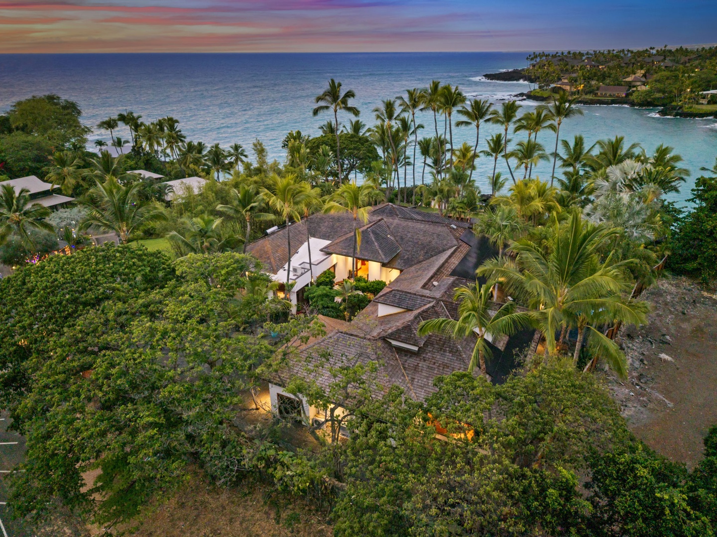 Kailua-Kona Vacation Rentals, Hahalua Bay Villa - Stunning tropical paradise with dramatic sunset colors painting the sky above this secluded beachfront retreat surrounded by lush palms and pristine waters.
