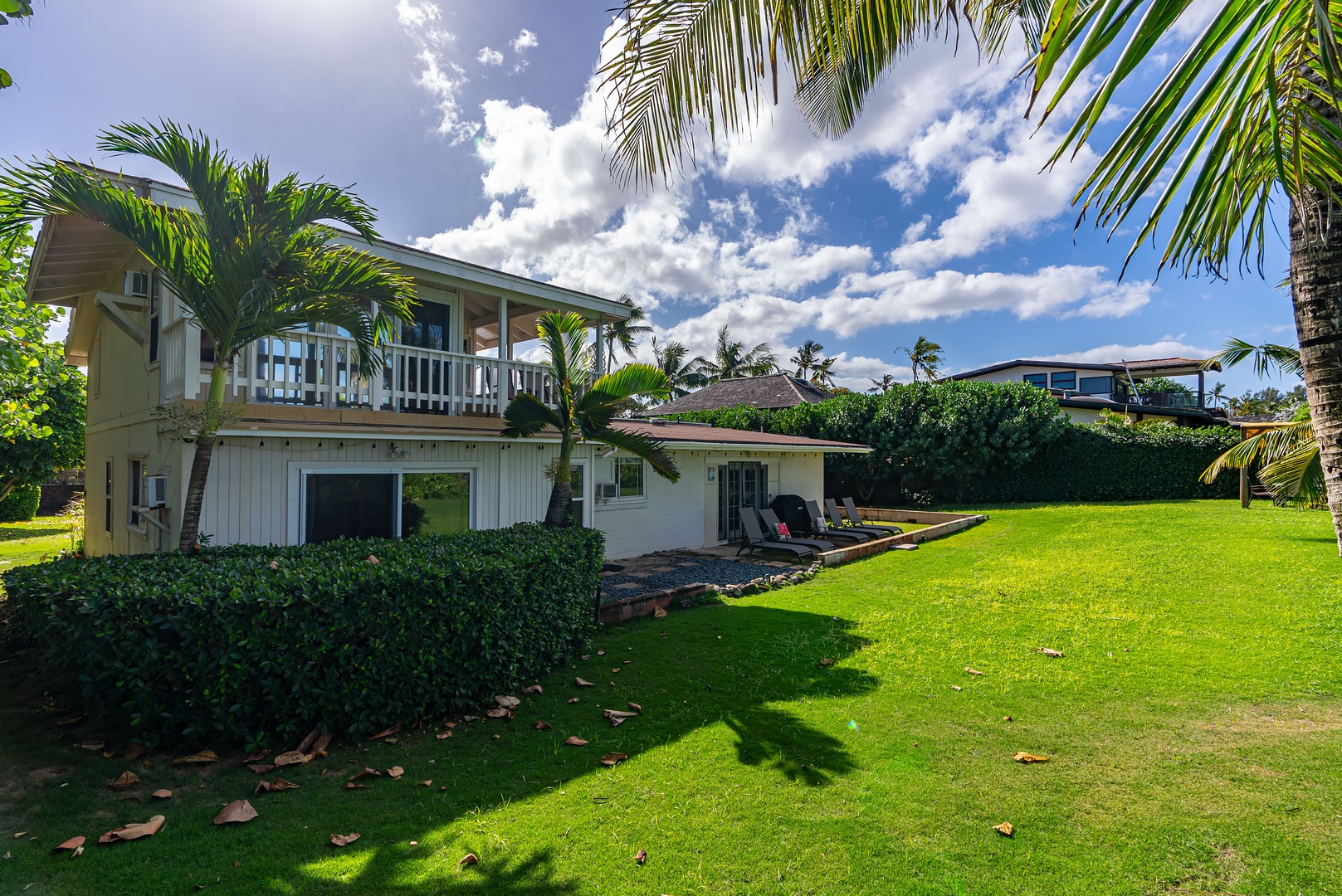 Haleiwa Vacation Rentals, North Shore Beachfront Resort - Spacious yard surrounded by tropical plants and ocean views.