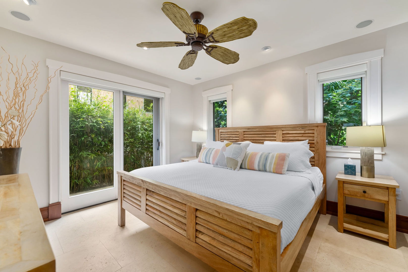 Kailua Vacation Rentals, Leaf House - Drift off in your serene bedroom, where natural light pours through glass doors, a gentle ceiling fan cools, and lush greenery frames your peaceful retreat.