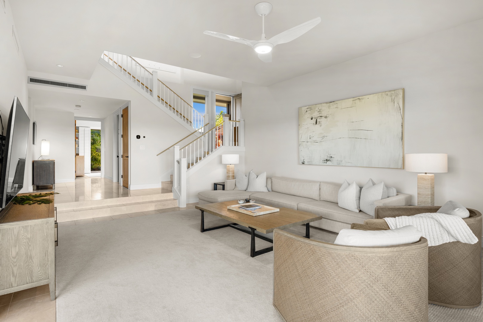 Kailua Kona Vacation Rentals, 3BD Palm Villa (130B) at Hualalai Resort - Relax in your bright, airy media room featuring plush seating, modern entertainment center, and soaring ceilings with elegant staircase.